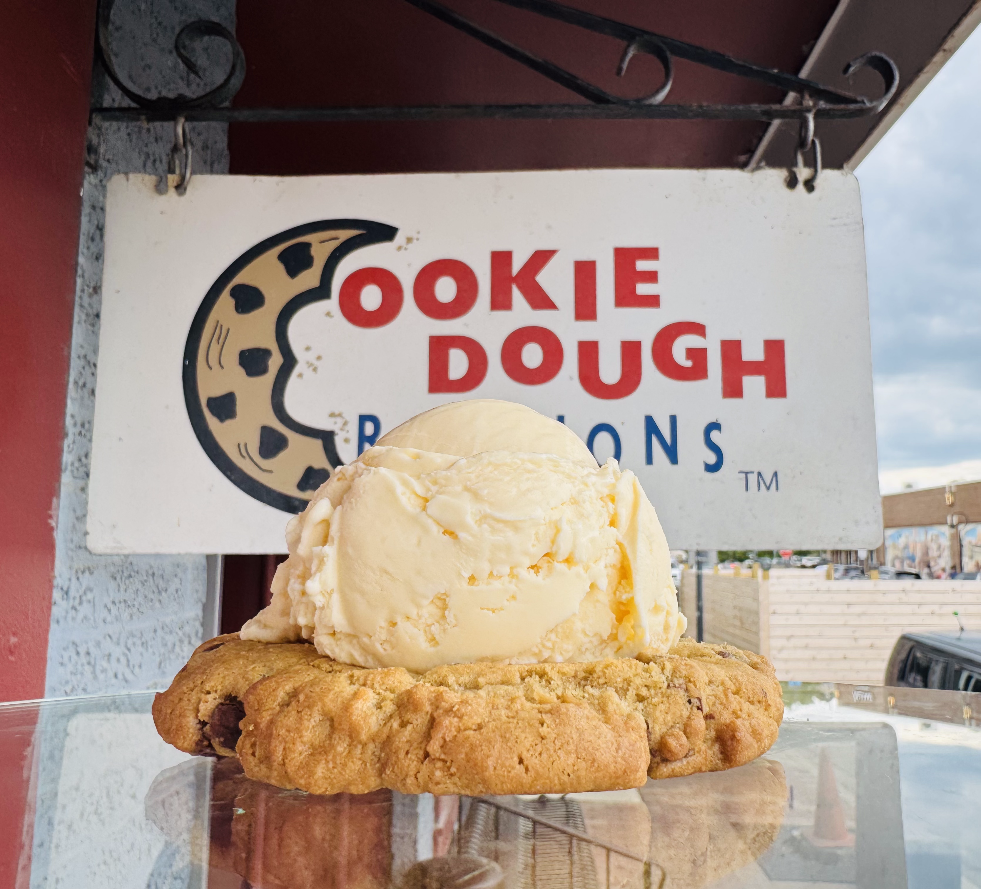 Vanilla ice cream on a warm cookie dough base in front of the Cookie Dough Creations sign